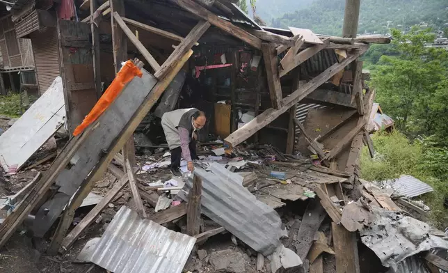 A person inspects his damaged shop following overnight shelling from Pakistan at Gingal village in Uri district, Indian controlled Kashmir, Friday, May 9, 2025. (AP Photo/Dar Yasin)