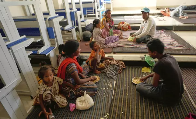 Villagers living along the border between India and Pakistan have food at a college where they have taken shelter following artillery shelling from Pakistan, on the outskirts of Jammu, India, Friday, May 9, 2025.(AP Photo/Channi Anand)