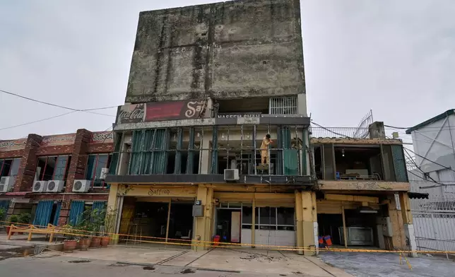Workers repair broken glass of a building at the parking area of Rawalpindi Cricket Stadium, where a suspected Indian drone was crashed on Thursday, in Rawalpindi, Pakistan, Friday, May 9, 2025. (AP Photo/Anjum Naveed)