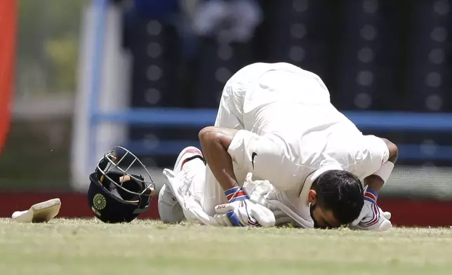 FILE - India's captain Virat Kohli kisses the field after scoring a double-century during day two of the first cricket Test match against West Indies at the Sir Vivian Richards Stadium in North Sound, Antigua, on July 22, 2016. (AP Photo/Ricardo Mazalan, File)