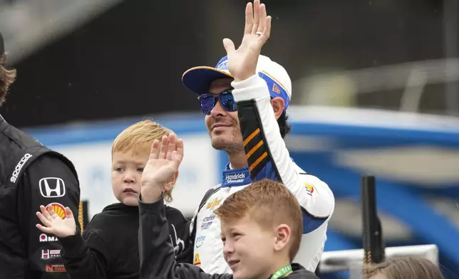 Kyle Larson waves as he's introduced before the start of the Indianapolis 500 auto race at Indianapolis Motor Speedway in Indianapolis, Sunday, May 25, 2025. (AP Photo/AJ Mast)