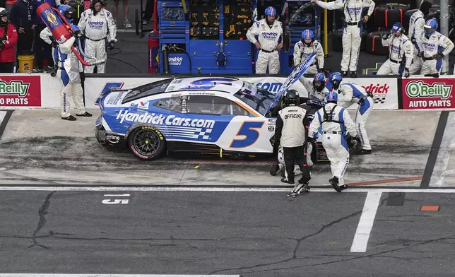 The pit crew for Kyle Larson looks under the hood of the car during a NASCAR Cup Series auto race at Charlotte Motor Speedway, Sunday, May 25, 2025, in Concord, N.C. (AP Photo/Matt Kelley)