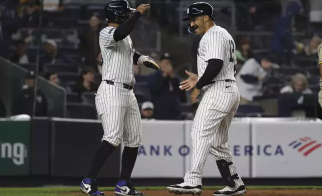 New York Yankees' Trent Grisham, right, reacts with Jorbit Vivas, left, after hitting a two-run home run which scored them during the third inning of a baseball game against the San Diego Padres, Monday, May 5, 2025, in New York. (AP Photo/Pamela Smith)