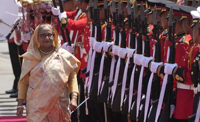 FILE - Bangladesh's Prime Minister Sheikh Hasina reviews an honor guard during a welcome ceremony at the government house in Bangkok, Thailand, Friday, April 26, 2024. (AP Photo/Sakchai Lalit, File)