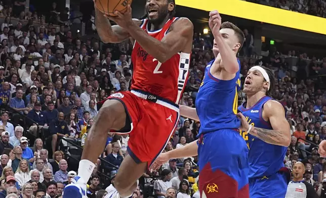 Los Angeles Clippers forward Kawhi Leonard, left, drives to the basket past Denver Nuggets guard Christian Braun, center, in the second half of Game 7 of an NBA basketball first-round playoff series Saturday, May 3, 2025, in Denver. (AP Photo/David Zalubowski)