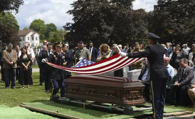 An American flag is folded during the interment for World War II U.S. Army Air Forces Staff Sgt. Eugene Darrigan at the cemetery behind St. Mary's church, Saturday, May 24, 2025, in Wappingers Falls, N.Y. Darrigan was buried in his hometown after his remains were recovered from a World War II bomber that crashed into the water off the coast of New Guinea on March 11, 1944. (AP Photo/Heather Khalifa)