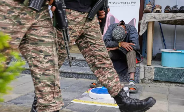 Indian soldiers patrol as a street vendor takes a nap after India and Pakistan reported no incidents of firing overnight, in Srinagar, Indian controlled Kashmir Monday, May 12, 2025. (AP Photo/Mukhtar Khan)