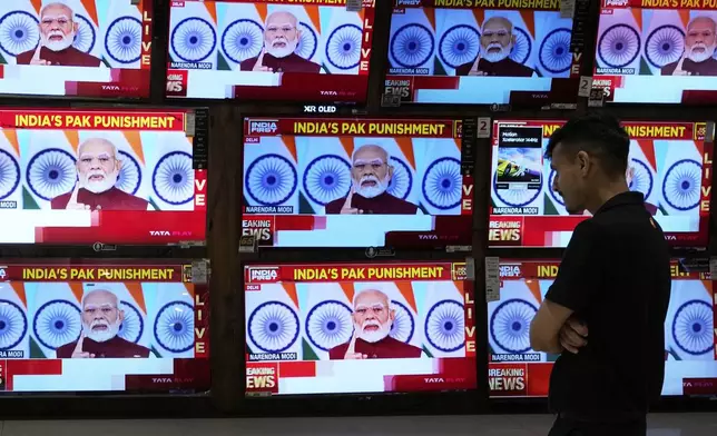 A man watches the live telecast of Indian Prime Minister Narendra Modi's speech on television screens at a shopping mall after 'Operation Sindoor' in Mumbai, India, Monday, May 12, 2025. (AP Photo/Rajanish Kakade)