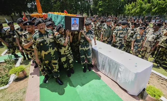 Indian Border Security Force (BSF) Soldiers carry a coffin containing the remains of a fellow soldier Deepak Chimngakham, who was killed in cross border Pakistani artillery shelling, in Jammu, India, Monday, May 12, 2025.(AP Photo/Channi Anand)