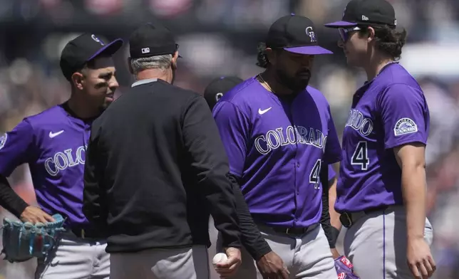 Colorado Rockies pitcher Germán Márquez, middle right, walks toward the dugout as manager Bud Black, middle left, makes a pitching change during the fifth inning of a baseball game against the San Francisco Giants in San Francisco, Sunday, May 4, 2025. (AP Photo/Jeff Chiu)