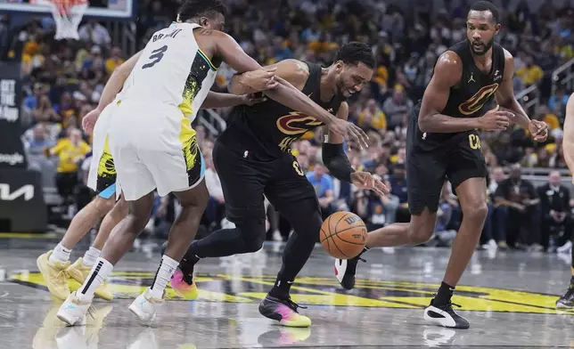 Cleveland Cavaliers guard Donovan Mitchell (45) chases down the ball against Indiana Pacers center Thomas Bryant (3) in the first half of Game 4 in the Eastern Conference semifinals of the NBA basketball playoffs in Indianapolis, Sunday, May 11, 2025. (AP Photo/Michael Conroy)