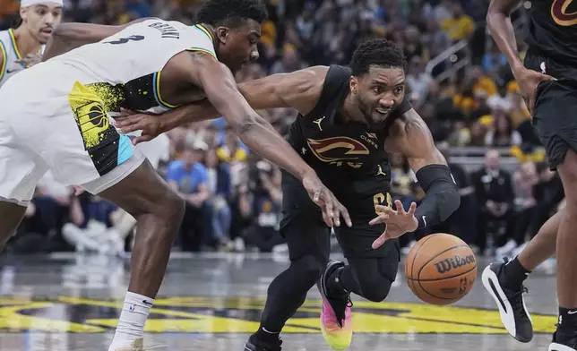 Cleveland Cavaliers guard Donovan Mitchell (45) chases down the ball against Indiana Pacers center Thomas Bryant (3) in the first half of Game 4 in the Eastern Conference semifinals of the NBA basketball playoffs in Indianapolis, Sunday, May 11, 2025. (AP Photo/Michael Conroy)
