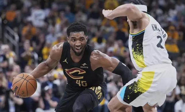 Cleveland Cavaliers guard Donovan Mitchell (45) drives to the basket against Indiana Pacers guard Andrew Nembhard (2) in the first half of Game 4 in the Eastern Conference semifinals of the NBA basketball playoffs in Indianapolis, Sunday, May 11, 2025. (AP Photo/Michael Conroy)