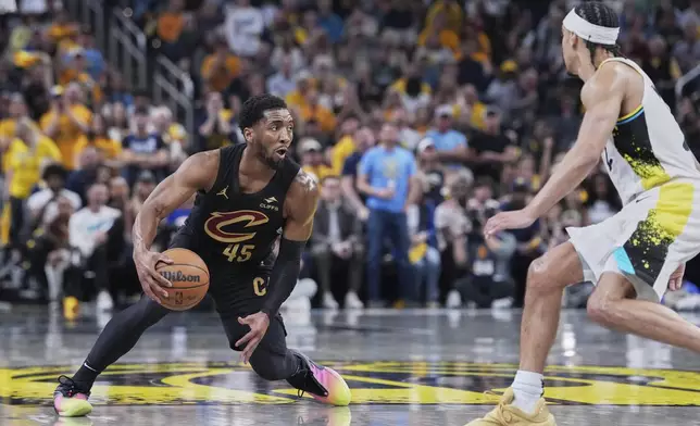 Cleveland Cavaliers guard Donovan Mitchell (45) drives to the basket against Indiana Pacers guard Andrew Nembhard (2) in the first half of Game 4 in the Eastern Conference semifinals of the NBA basketball playoffs in Indianapolis, Sunday, May 11, 2025. (AP Photo/Michael Conroy)