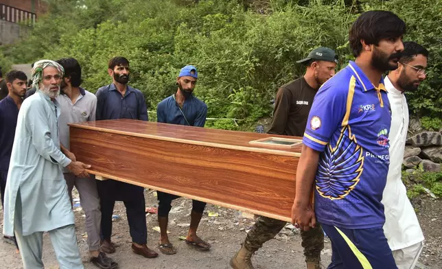Volunteers carry a body after recovering it from the rubble of a mosque building damaged by a suspected Indian missile attack near Muzaffarabad, the capital of Pakistan controlled Kashmir, on Wednesday, May 7, 2025. (AP Photo/M.D. Mughal)