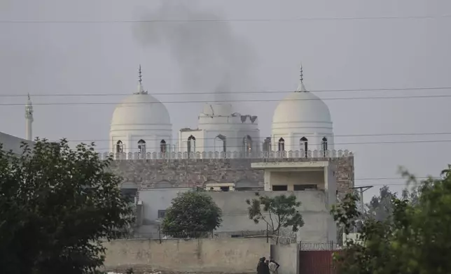 Local residents stand outside a mosque of an Islamic seminary partially damaged by a suspected Indian missile attack, outskirts of Bahawalpur, Pakistan, Wednesday, May 7, 2025. (AP Photo/Asim Tanveer)