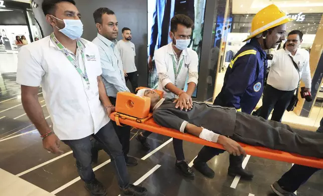 Fire brigade workers and paramedics participates in a security mock drill at a mall in Ahmedabad, India, Wednesday, May 7, 2025, amid rising fears of wider conflict following India's strikes in Pakistan. (AP Photo/Ajit Solanki)