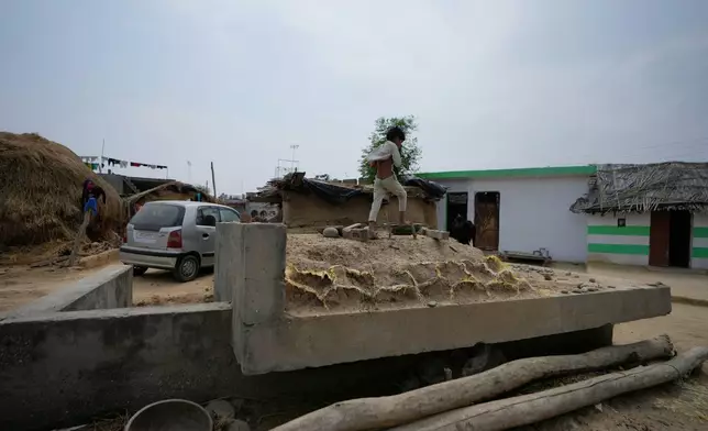 Indian child walk on bunker near India - Pakistan International border at in Jora farm village, in Ranbir Singh Pura about 35 kilometers (22 miles) from Jammu, India, Tuesday, May 6, 2025. (AP Photo/Channi Anand)