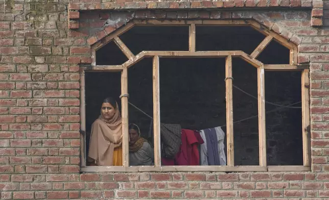 A woman looks at a part of an aircraft which landed in the compound of a mosque at Pampore in Pulwama district of Indian controlled Kashmir, Wednesday, May 7, 2025. (AP Photo/Dar Yasin)