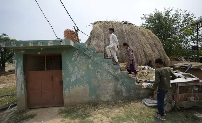 Indian children walk on bunker near India - Pakistan International border at in Jora farm village, in Ranbir Singh Pura about 35 kilometers (22 miles) from Jammu, India, Tuesday, May 6, 2025. (AP Photo/Channi Anand)