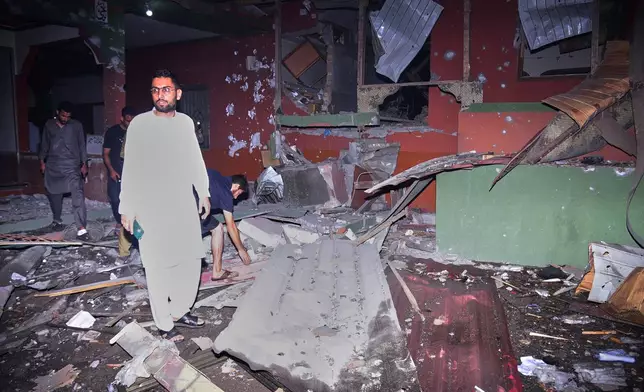 Local residents examine a building damaged from a suspected Indian missile attack near Muzaffarabad, the capital of Pakistan controlled Kashmir, in Wednesday, May 7, 2025. (AP Photo/M.D. Mughal)