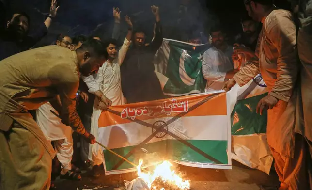 Protesters burn an Indian flag during a demonstration condemning Indian missile strikes, in Hyderabad, Pakistan, Wednesday, May 7, 2025. (AP Photo/Pervez Masih)