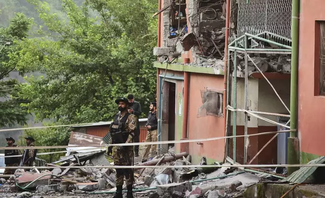 Army soldiers stand guard at a mosque building damaged by a suspected Indian missile attack near Muzaffarabad, the capital of Pakistan controlled Kashmir, on Wednesday, May 7, 2025. (AP Photo/M.D. Mughal)