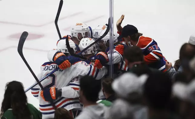 Edmonton Oilers players celebrate after left wing Evander Kane scored against the Dallas Stars during the third period of Game 5 of the Western Conference finals in the NHL hockey Stanley Cup playoffs, Thursday, May 29, 2025, in Dallas. (AP Photo/Gareth Patterson)