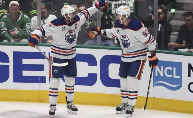 Edmonton Oilers right wing Corey Perry, right, celebrates with center Connor McDavid after scoring during the first period of Game 5 of the Western Conference finals in the NHL hockey Stanley Cup playoffs, Thursday, May 29, 2025, in Dallas. (AP Photo/Gareth Patterson)