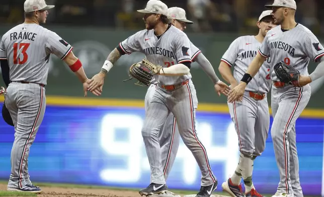 Minnesota Twins players congratulate one another after a baseball game against the Milwaukee Brewers, Friday, May 16, 2025, in Milwaukee. (AP Photo/Jeffrey Phelps)