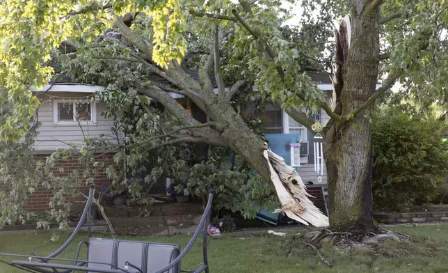 A tree lays on a house in Dorr, Mich., after a severe storm ripped across Michigan the night before, on Friday, May 16. 2025. (Neil Blake /The Grand Rapids Press via AP)