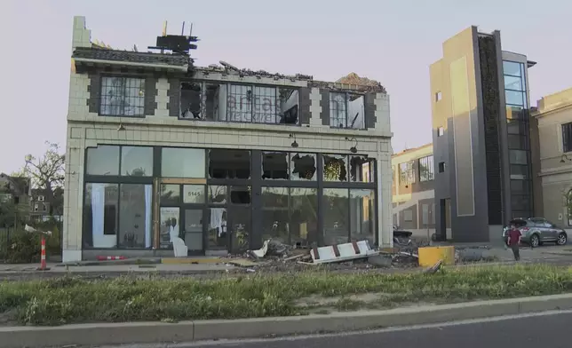 A building is damaged as debris covers the ground after a severe storm passed the area on Saturday, May 17, 2025 in St. Louis, Mo. ( KMOV via AP)