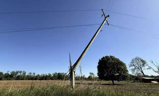 A snapped utility pole stands awkwardly off of 92nd Street near Caledonia, Mich. on Friday, May 16. 2025. (Neil Blake/The Grand Rapids Press via AP)