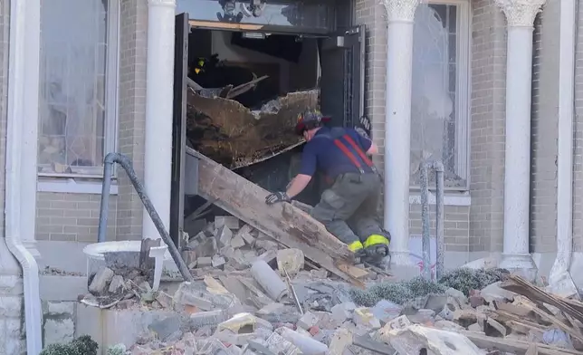 A firefighter enters a damaged building after a severe storm passed the area on Saturday, May 17, 2025 in St. Louis, Mo. ( KMOV via AP)