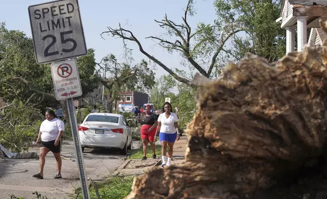 People survey damage after a severe storm moved through Friday, May 16, 2025, in St. Louis. (AP Photo/Jeff Roberson)