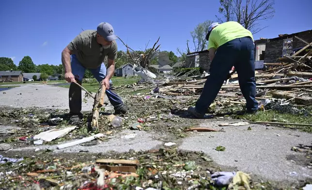 Volunteers help clear debris from a road following severe storms last night in London, Ky., Saturday, May 17, 2025. (AP Photo/Timothy D. Easley)
