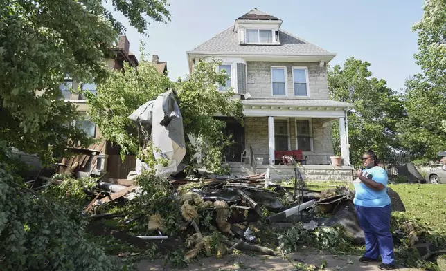 People survey damage after a severe storm moved through Friday, May 16, 2025, in St. Louis. (AP Photo/Jeff Roberson)