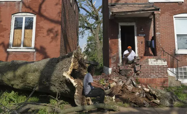 People survey damage after a severe storm moved through Friday, May 16, 2025, in St. Louis. (AP Photo/Jeff Roberson)