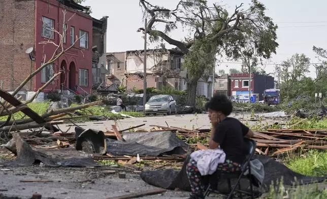 People survey damage after a severe storm moved through Friday, May 16, 2025, in St. Louis. (AP Photo/Jeff Roberson)