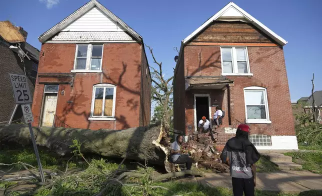 People survey damage after a severe storm moved through Friday, May 16, 2025, in St. Louis. (AP Photo/Jeff Roberson)