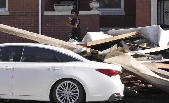 A person looks at damage caused by a severe storm moved through Friday, May 16, 2025, in St. Louis. (AP Photo/Jeff Roberson)