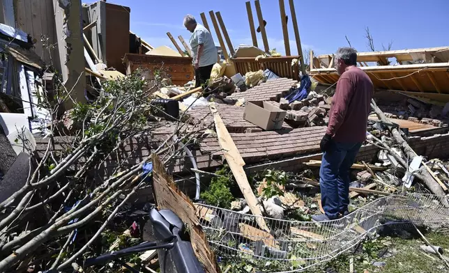 Doris Hensley, center, and Don Allen look over the remains of her home following severe weather in London, Ky., Saturday, May 17, 2025. (AP Photo/Timothy D. Easley)