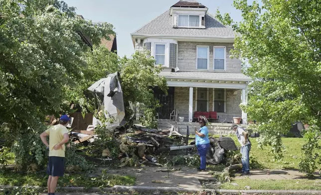 People survey damage after a severe storm moved through Friday, May 16, 2025, in St. Louis. (AP Photo/Jeff Roberson)