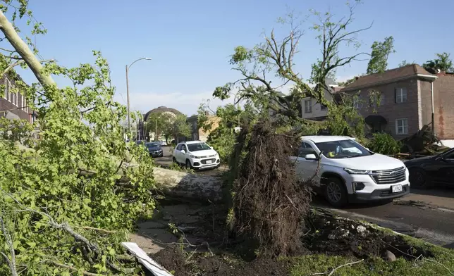 Drivers navigate around debris in the roadway after a severe storm moved through Friday, May 16, 2025, in St. Louis. (AP Photo/Jeff Roberson)
