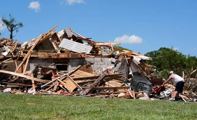 A person looks through the damage at a destroyed home, Saturday, May 17, 2025, in London, Ky (AP Photo/Carolyn Kaster)