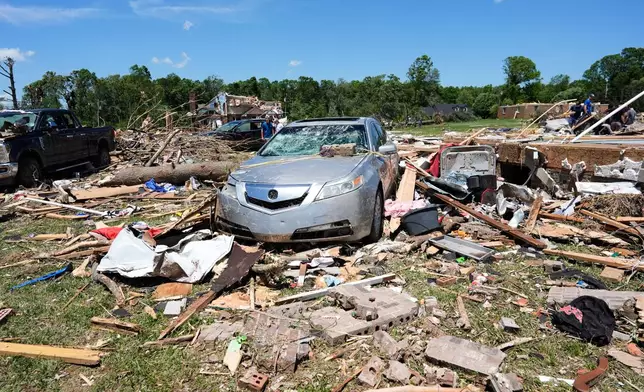Debris covers the ground and damaged vehicles after a severe storm passed the area on Saturday, May 17, 2025, in London, Ky. (AP Photo/Carolyn Kaster)
