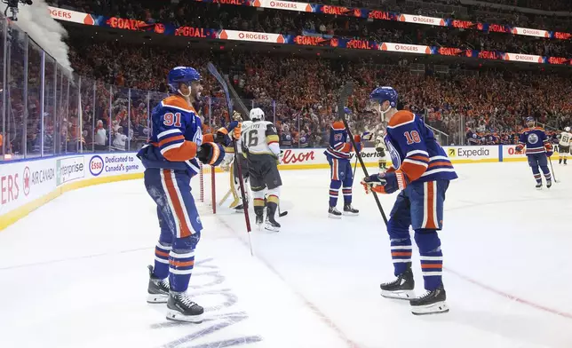 Edmonton Oilers' Evander Kane (91) and Zach Hyman (18) celebrate after a goal against the Vegas Golden Knights during the second period of Game 4 of a second-round NHL hockey playoff series in Edmonton, Alberta, Monday, May 12, 2025. (Jason Franson/The Canadian Press via AP)
