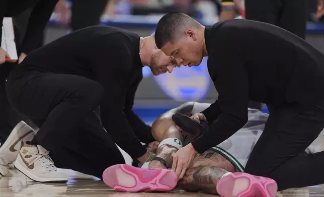 Trainers check on Boston Celtics' Jayson Tatum after he was injured during the second half of Game 4 in the Eastern Conference semifinals of the NBA basketball playoffs against the New York Knicks Monday, May 12, 2025, in New York. (AP Photo/Frank Franklin II)