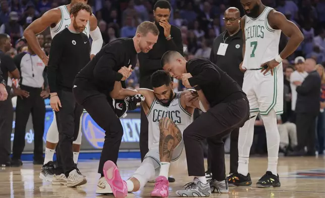 Trainers help Boston Celtics' Jayson Tatum (0) off the court after he was injured during the second half of Game 4 in the Eastern Conference semifinals of the NBA basketball playoffs against the New York Knicks Monday, May 12, 2025, in New York. (AP Photo/Frank Franklin II)