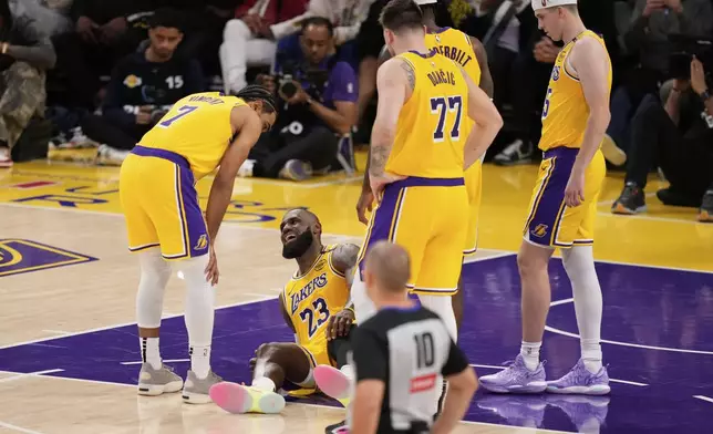 Los Angeles Lakers forward LeBron James lays on the floor after injuring his knee during the second half in Game 5 of an NBA basketball first-round playoff series against the Minnesota Timberwolves, Wednesday, April 30, 2025, in Los Angeles. (AP Photo/Mark J. Terrill)